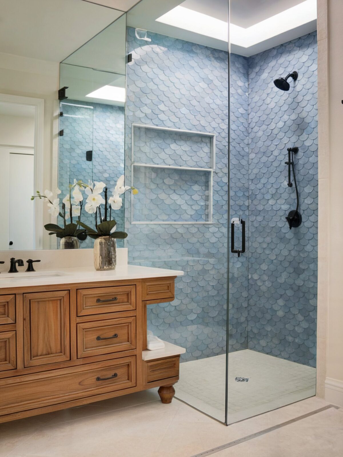 Coastal wall decor for bathroom with a well decorated glass enclosed dominant feature of a blue, fish scale patterned wall